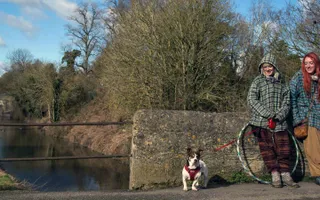 Two girls walk a dog on the Devizes towpath