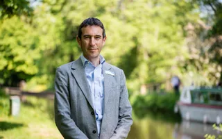 Man posing for photo in a suit on a sunny day