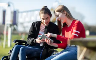 Two ladies looking at a phone on the towpath