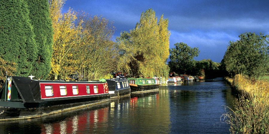 Boats moored along towpath of canal