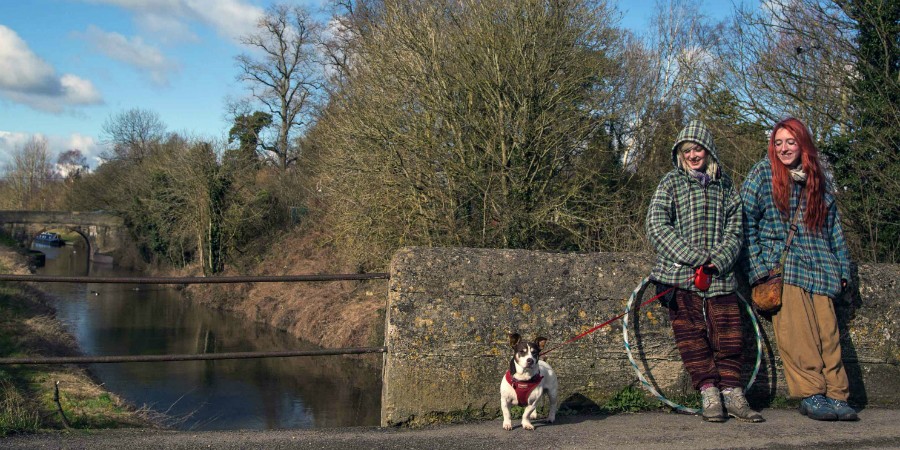 Two girls walk a dog on the Devizes towpath