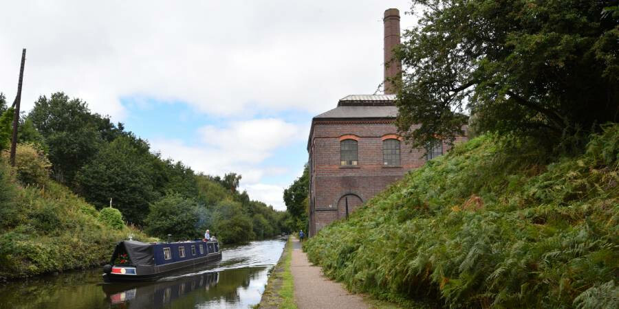 A towpath walking route past a historic building