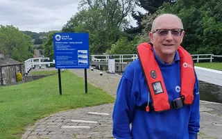 A volunteer poses by a lock