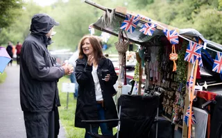 Two people outside a stall on a canal