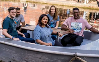 Group of friends sat in boat wearing Teemill clothing