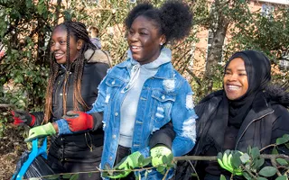 Group of girls on work experience in Leeds, laughing and chatting while collecting litter