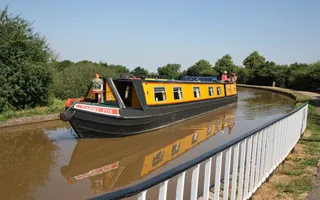 Boat named 'Canny Fox' passes across a small aqueduct