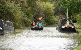 Narrowboat passes moored boats