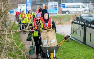 Group of young people on the canal planting trees