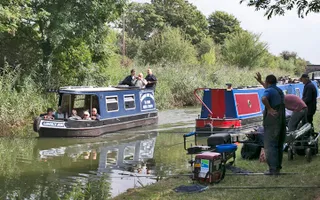 Angler waving to passengers of passing boat on Slough Arm