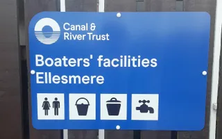 Canal & River Trust sign saying 'Boaters' facilities Ellesmere' with illustrations of toilets, water, bins, and disposal point