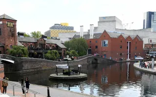 Three canals join in Birmingham centre, with the city skyline in the background.