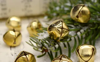Close up of golden bells with sheet music in the background and thistle