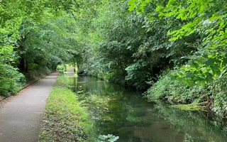 Canal and towpath with lots of green trees overhanging