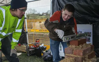 Apprentice Sam Pointer helps Keith Burgman with bricklaying