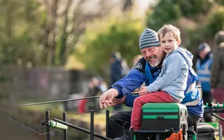Man and boy fishing by canal