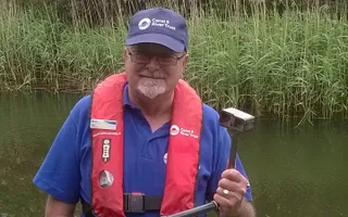 Volunteer poses with a windless in front of the canal