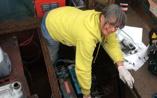 A lady carrying out maintenance on a boat engine