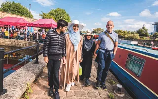 Family walking past moored narrowboats