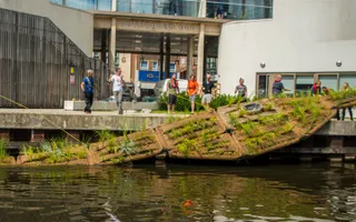 Volunteers lowering a floating reed bed into the canal