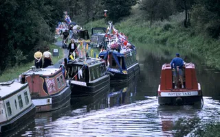 Water taxi passing moored boats on canal
