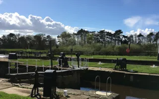 Two locks alongside each other with grassy banks between on a sunny day