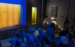 A group of people pointing at an underwater window
