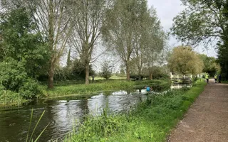 Quiet stretch of canal with kayaker and two men in the distance
