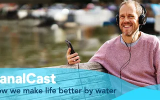 A man listening to a podcast by the canal