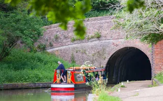 Red and green boat entering Blisworth Tunnel