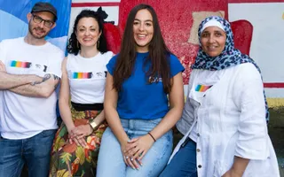 A group of 4 people standing next to examples of street art
