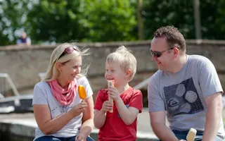 A family eating ice cream by the canal