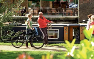 Walkers, a cyclist, angler and boater on the Grand Union Canal