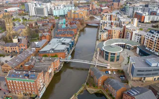 Drone view over leeds waterfront showing canal surrounded by tall buildings
