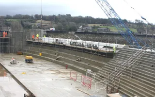 wide shot of a contruction site at a reservoir with crane in the background