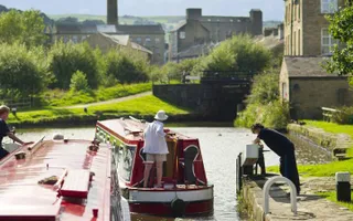 A boater passing through a canal lock in Sowerby Bridge