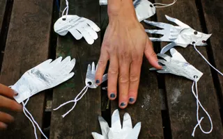Hand on table with other paper hands