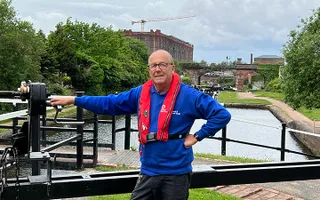 A volunteer lock keeper winds a lock paddle