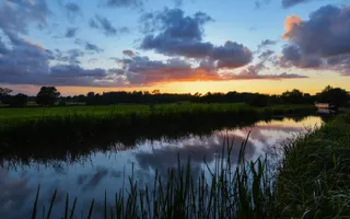 Sun sets over a canal and reflects in the canal