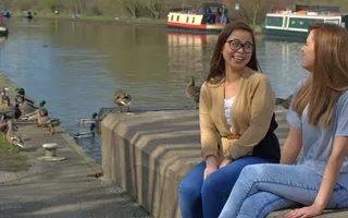 Two girls sitting by the canal