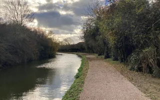 Nearly revamped towpath along a canal with large bushes surrounding the area