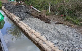 Stones and sandbags on the bank of the canal