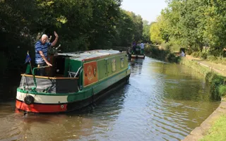 A man enjoying steering a narrowboat