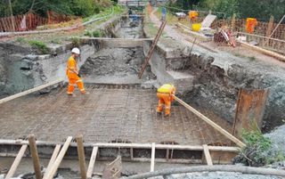 Two workers in high vis working on some brick work