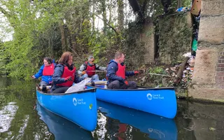 Group of people in canoes litter picking