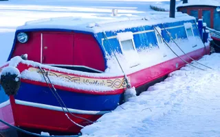 A boat moored in the snow on the Leeds & Liverpool Canal