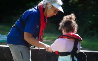 Volunteer lock keeper helping young child with the locks