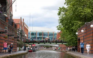 An image looking down the canal towards a bridge with people walking across it
