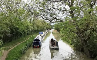 Narrowboat passes moored boats on the Leicester Line, Grand Union Canal