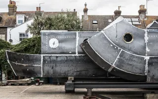 Metal art Sculpture of a narrow boat infront of a row of houses